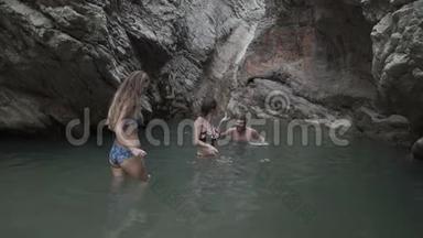 几个男人和女人在野生的山湖和瀑布里洗澡。 <strong>游山玩水</strong>的游客